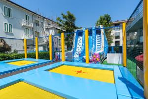 un parque infantil con dos camas elásticas. en Hotel Rosalba - Valentini Family Village en Bellaria-Igea Marina