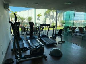 un gimnasio con varias máquinas cardiovasculares y una gran ventana en Intercity BH Expo en Belo Horizonte