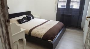 een slaapkamer met een bed met een tafel en een raam bij Piso casco antiguo in Vitoria-Gasteiz