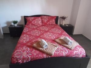Un dormitorio con una cama roja con toallas. en ARIADNIS 3 BEDs apt en Pomos