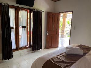 a bedroom with a bed and a large window at Serongga guest house in Lebih