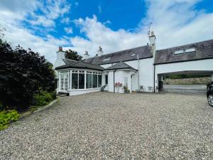 an exterior view of a white house with a garage at Lovely 5-Bed House in Lundin Links coastal village in Lundin Links