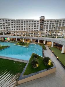 a large apartment building with a large swimming pool at Elegant duplex with pool frontAUC in Cairo