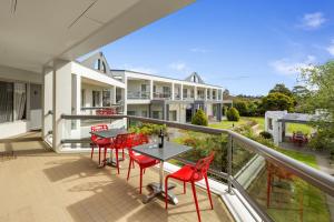 a balcony of a house with red chairs and a table at Doncaster Apartments by Nightcap Plus in Doncaster