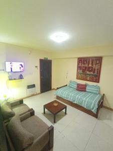 a room with a bed and a couch and a tv at Departamento Temporario Céntrico Mendoza in Mendoza