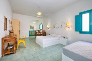 a bedroom with a bed and a table and a chair at Nissia Beach Apartments & Suites in Kamari