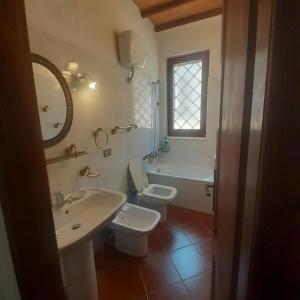 baño con lavabo y aseo y ventana en Villa Le Palmine, en Palazzone