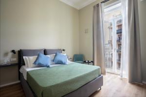 una camera da letto con un letto con cuscini blu e una finestra di Mori's b&b a Palermo