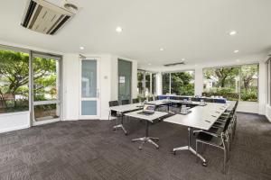 a large room with tables and chairs and windows at Doncaster Apartments by Nightcap Plus in Doncaster