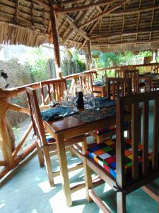 a wooden table and chairs in a restaurant at Eden Paradise in Michamvi