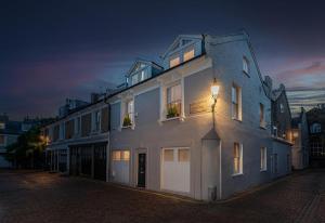 a large white building on a street at night at NEW Stunning 5BD Mews House in London