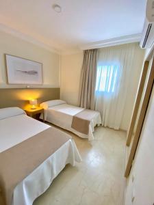ein Hotelzimmer mit 2 Betten und einem Fenster in der Unterkunft Luxury Villa Masca private heated pool in Adeje