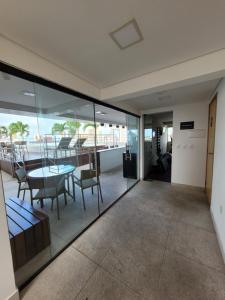 a room with glass walls and a table and chairs at Espetacular Apart hotel Manaira in João Pessoa