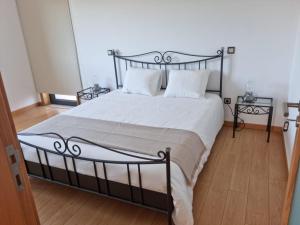 a bedroom with a black and white bed with two tables at Florindo - Lafões Guest House in Oliveira de Frades