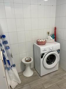 een badkamer met wasmachine en toilet bij CORNELIA´S HOME 4 Primera linea de playa in Los Cristianos +3 foto's