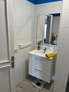 een witte badkamer met een wastafel en een spiegel bij CORNELIA´S HOME 4 Primera linea de playa in Los Cristianos