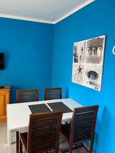 een blauwe kamer met een witte tafel en stoelen bij CORNELIA´S HOME 4 Primera linea de playa in Los Cristianos