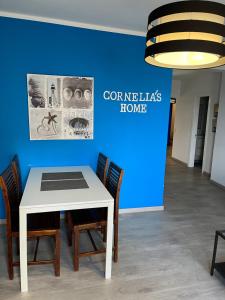 een tafel met stoelen en een bordje met de tekst 'comelias home' bij CORNELIA´S HOME 4 Primera linea de playa in Los Cristianos