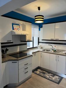een keuken met witte kasten en een spoelbak bij CORNELIA´S HOME 4 Primera linea de playa in Los Cristianos