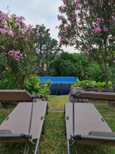 - deux lits dans un jardin avec des fleurs roses dans l'établissement Casa Rural en Candeleda con piscina y un maravilloso jardín, à Candeleda