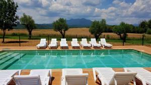 einen Pool mit Liegestühlen und einem Pool in der Unterkunft Masía para grupos con piscina privada28 pax in Girona