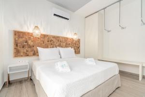 um quarto com uma cama branca com duas toalhas em COSTA VASIA Boutique Apartments em Vrachati