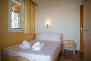a bedroom with a bed with towels on it at Amalia Apartments in Stoupa