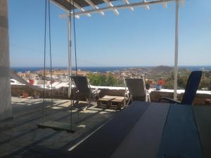 a view from the balcony of a house with a table and chairs at Cycladic House in Vári