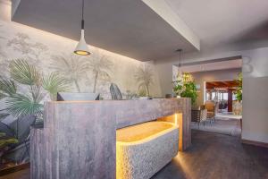a lobby with a bar with plants on the wall at Hotel Baia Imperiale in Campo nell'Elba