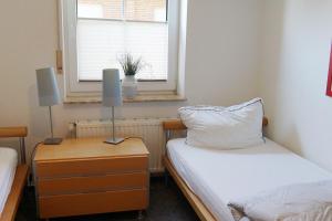 ein kleines Schlafzimmer mit 2 Betten und einem Fenster in der Unterkunft 50080... in Carolinensiel