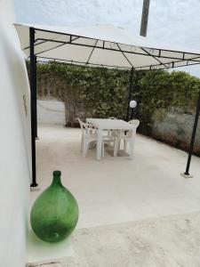 a table and a green vase on a patio at Poggio Fiorito in Porto Cesareo