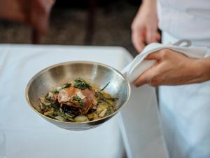 a person holding a bowl of food at Hotel Rauter in Matrei in Osttirol