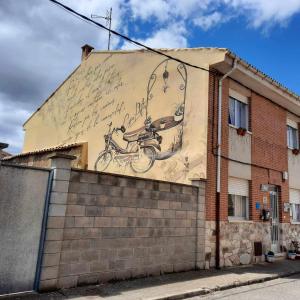 un dipinto di una moto sul lato di un edificio di CASA PITA Siente paz y calma en un lugar con encanto Bbc BTT niños pets a San Justo de la Vega