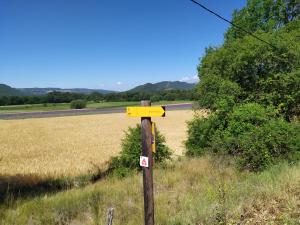 a yellow sign on a pole in the middle of a field at les mésanges in Chaffaut-Lagremuse +3 photos