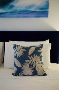 a pillow sitting on top of a bed with a painting at Bay Of Fires Apartments in St Helens