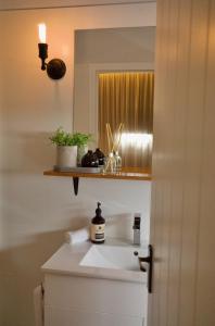 y baño con lavabo blanco y espejo. en Bay Of Fires Apartments, en St Helens