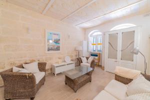 ein Wohnzimmer mit einem Sofa, Stühlen und einem Tisch in der Unterkunft Central Valletta Townhouse-Hosted by Sweetstay in Valletta
