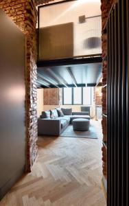 a living room with a couch and a brick wall at LANCETTI Stylish Loft - hosted by Sweetstay in Milan