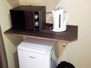 a microwave and a toaster oven on a shelf at House 205 in Vanderbijlpark