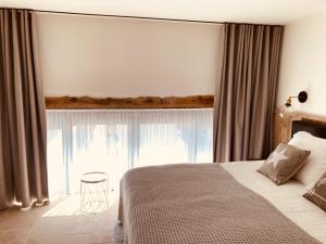 um quarto com uma cama e uma grande janela em De Molenhoeve em Voeren
