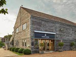 a large brick building with a sign in front of it at Bridewell Cottage in the heart of Tenterden - Pass The Keys in Tenterden