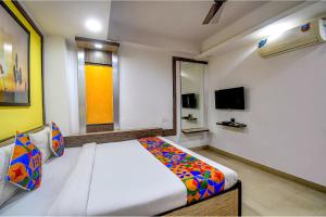 FabHotel Adri Hotel's في Dum Dum: غرفة نوم فيها سرير وتلفزيون