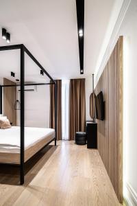 a bedroom with a canopy bed and a wooden floor at Blanche Cliff Apartments in Sveti Stefan