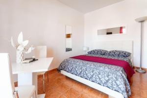 a white bedroom with a bed and a white desk at Apartments Dobrila in Hvar