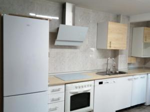 a kitchen with white appliances and a white refrigerator at Apartamento Bornos&Huesca in Huesca +4 photos