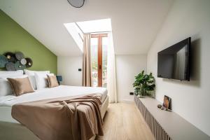 a bedroom with a bed and a flat screen tv at Blanche Cliff Apartments in Sveti Stefan