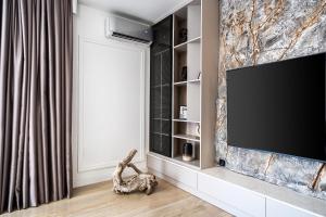a living room with a flat screen tv on a wall at Blanche Cliff Apartments in Sveti Stefan