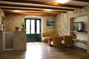 a living room with a table and chairs and a tv at Castello Gulich in Poreč
