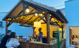 un hombre de pie en un bar con una bebida en Camping Paradis Family les Rives de l'Hérault en Gignac