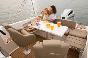 a woman and a little girl sitting at a table on a boat at Guest accommodation house Greta in Tribunj